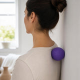 Persona usando una bola de masaje AirNova contra la pared